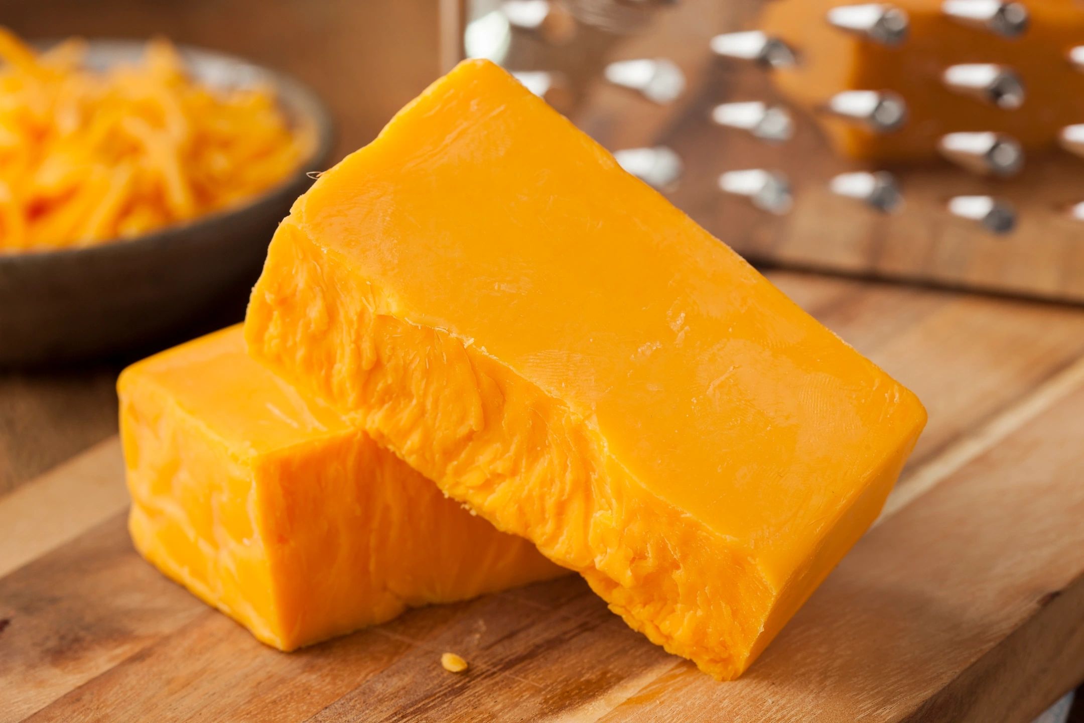 Bloques de queso en una tabla de cortar de madera.