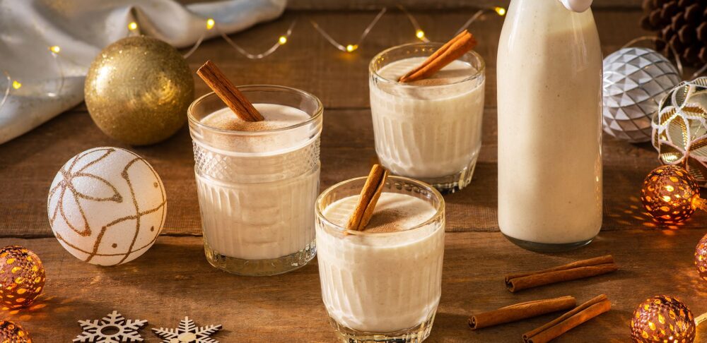 Vasos de coquito con canela en una mesa festiva.