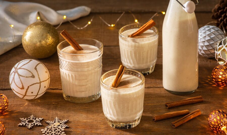 Vasos de coquito con canela en una mesa festiva.