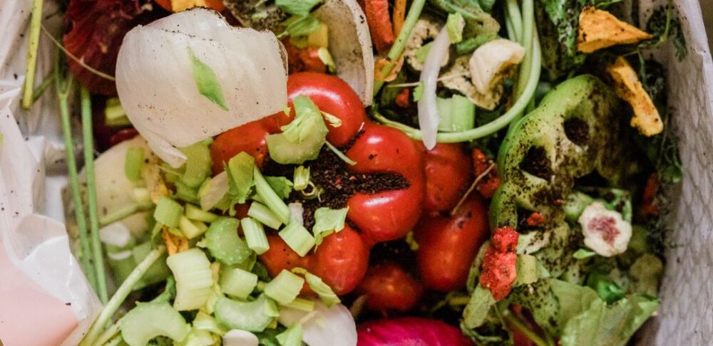 Una bolsa de basura llena de desechos de vegetales y comida.