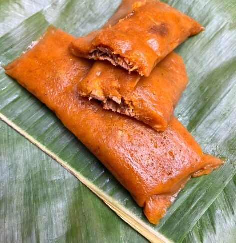 Un pastel, plato tradicional, servido sobre una hoja de plátano.