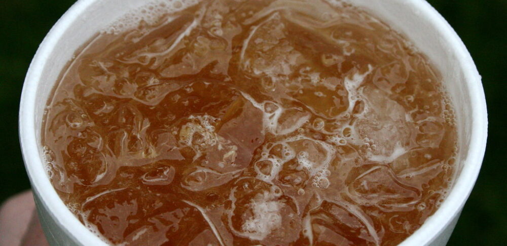 Vista cercana de una bebida fría en un vaso blanco, lleno de hielo y mavi.