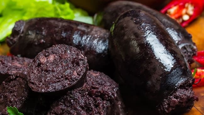 Morcilla, un embutido tradicional, servido con vegetales frescos.