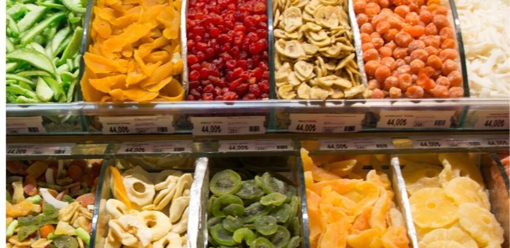 Variedad de frutas deshidratadas exhibidas en un mercado.