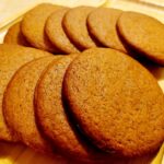 Un plato con varias galletas Cuca marrones, dispuestas en una fila. Las galletas tienen una textura suave y están doradas uniformemente.