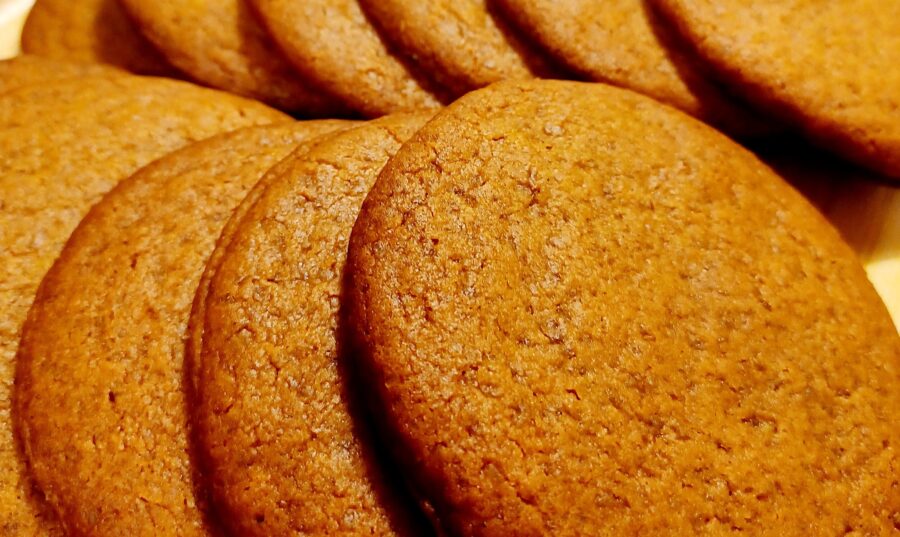 Un plato con varias galletas Cuca marrones, dispuestas en una fila. Las galletas tienen una textura suave y están doradas uniformemente.