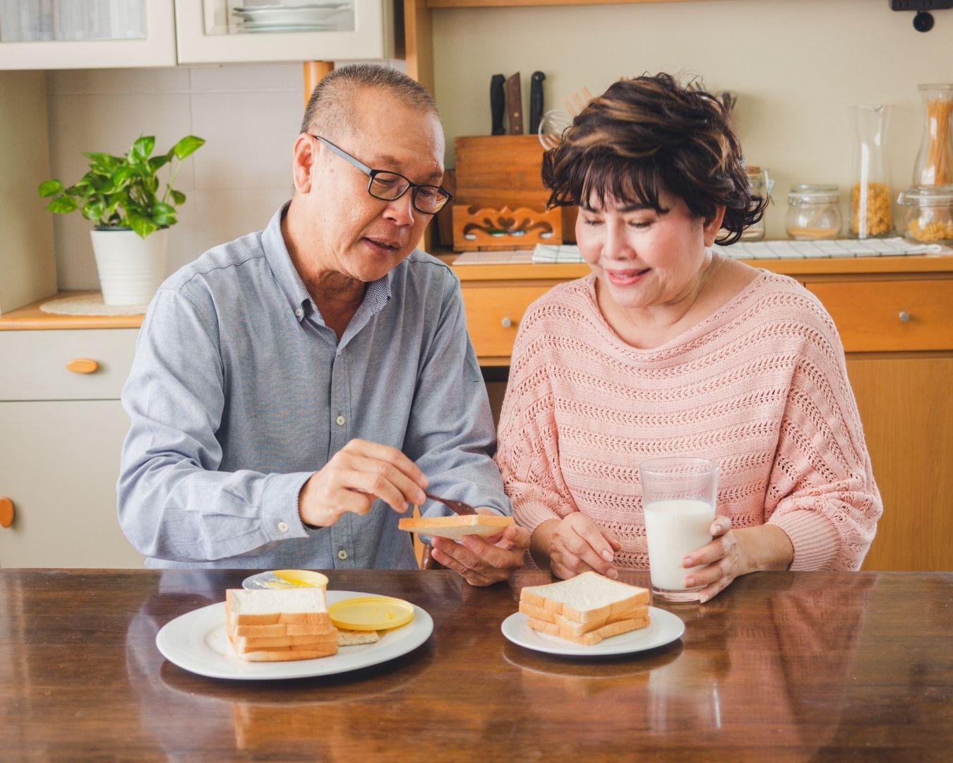 Pareja de adultos mayores comparte un desayuno en casa mientras practica una alimentación consciente basada en las señales de hambre y saciedad.